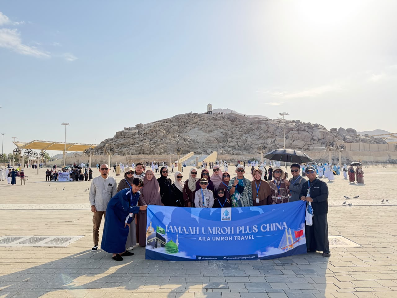 Jamaah umroh Aila berfoto dengan spanduk di depan Jabal Rahmah